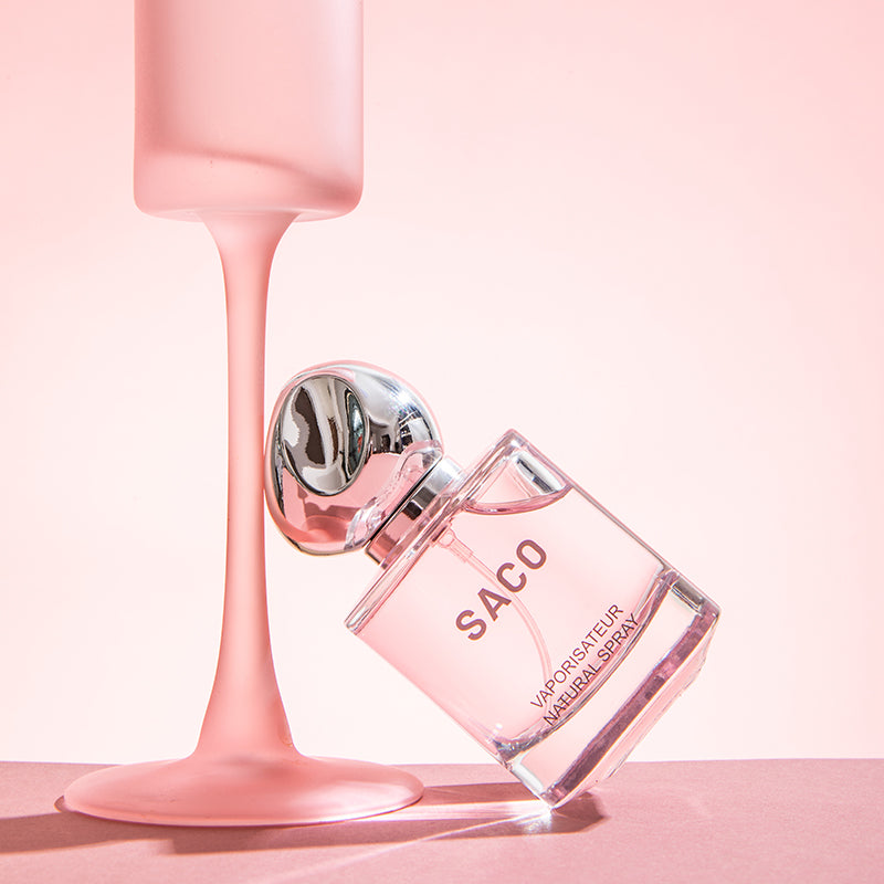 SACO Perfume bottle with elegant design and pink liquid, showcasing long-lasting luxury scent.