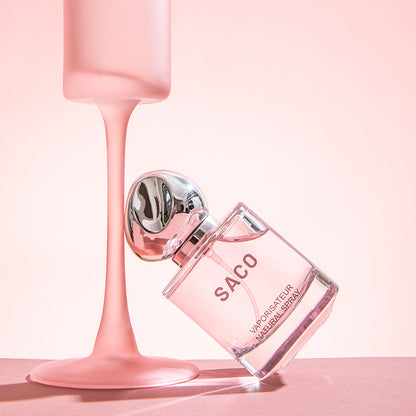 SACO Perfume bottle with elegant design and pink liquid, showcasing long-lasting luxury scent.